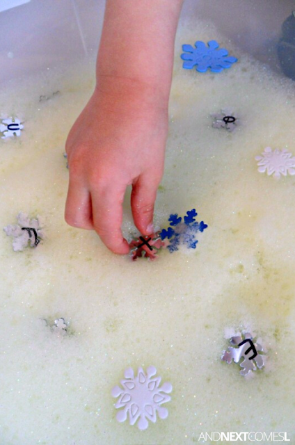 Close up of hand picking snowflakes out of a winter sensory bin