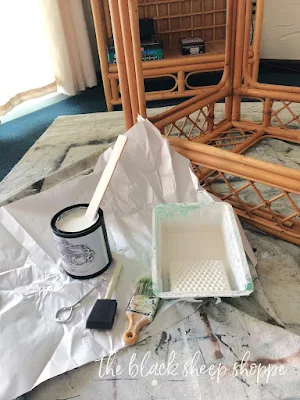 Paint supplies set out for painting rattan end table.