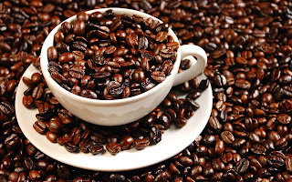 a coffee cup filled and surrounded by coffee beans