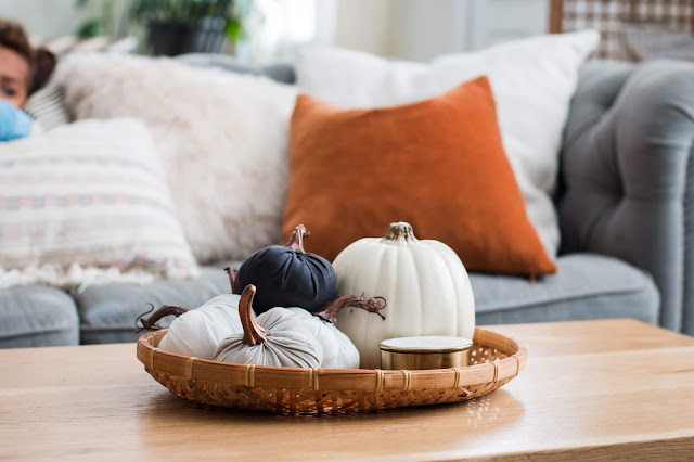 Pumpkins and a candle in a tray for simple fall decorating