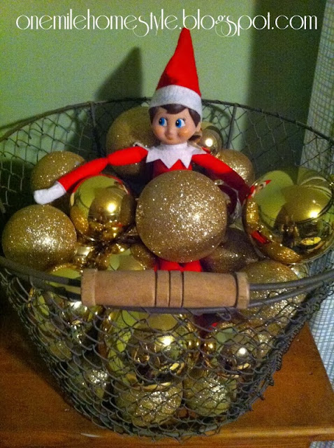 Elf on the Shelf in a basket of ornaments