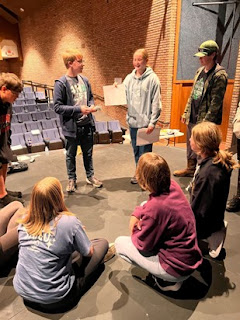 4-H girl giving a speech to group of youth gathered in a circle