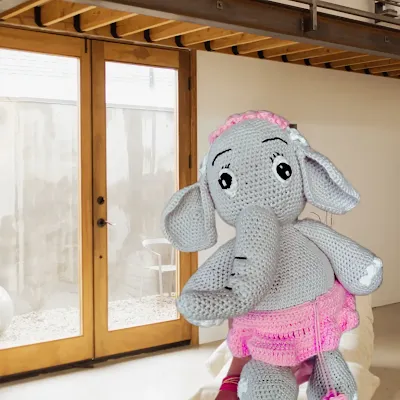 Stuffed toy amigurumi grey color elephant with pink skirt and white and pink headband