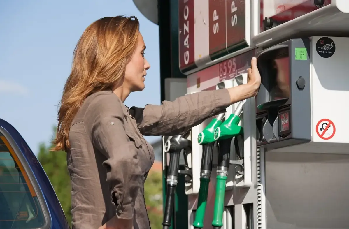 Una donna guarda il prezzo dei carburanti