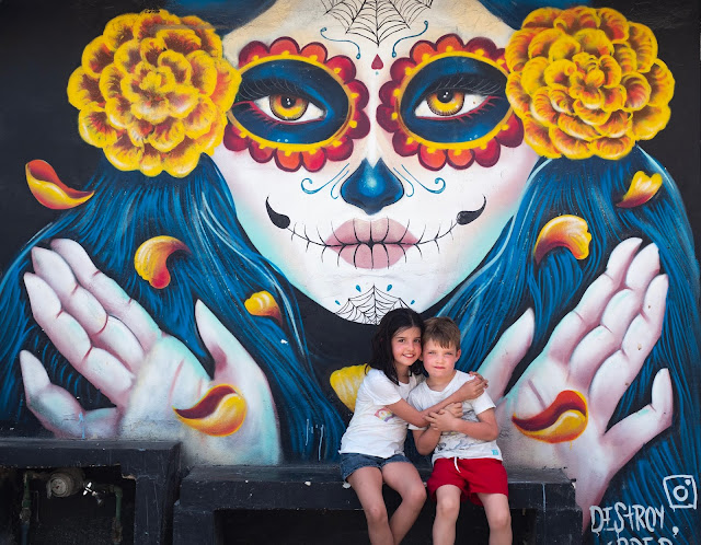 Mural de Catrina con niños sentados delante