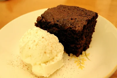 Slice of Guinness gingerbread with vanilla ice cream.