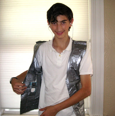 J, displaying the iPod pocket in his duct tape vest