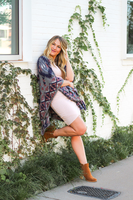 girl leaning against wall wrapped in aztec poncho