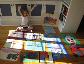 girl surrounded by her kindergarten art