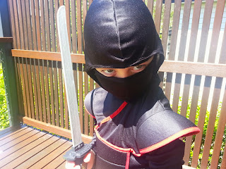 Photo of young boy in black and red ninja outfit