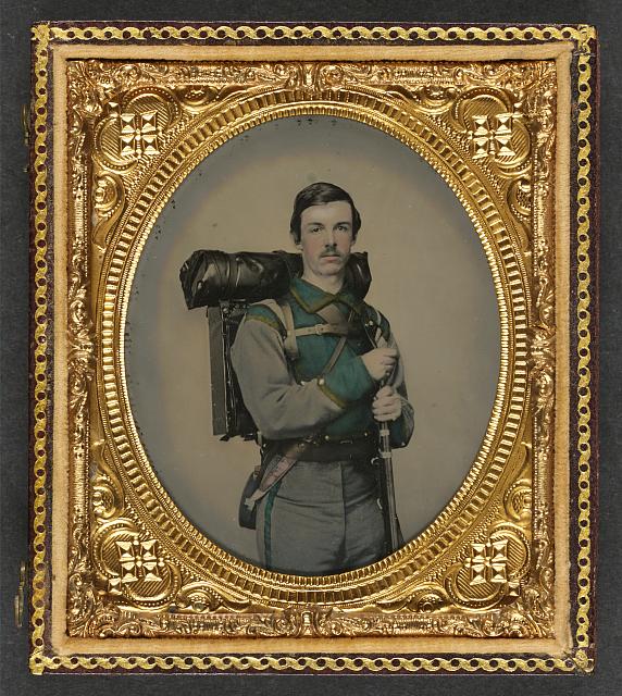 Photograph shows a soldier in 1861 in a Confederate uniform of Company E, “Lynchburg Rifles,” 11th Virginia Infantry Volunteers holding 1841 “Mississippi” rifle, Sheffield-type Bowie knife, canteen, box knapsack, blanket roll, and cartridge box. Photo Credit: Charles R. Rees/Library of Congress