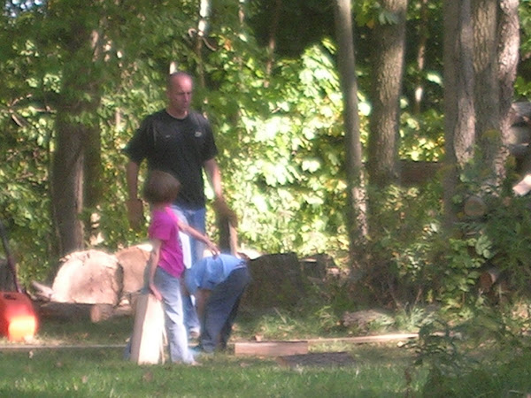 The kids helping stack wood