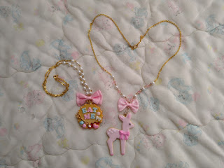 A jam cookie that says eat me with a bow and pearl chain and a pink dear wearing a bow with a chain that has pearls, plastic gem beads and a bow.