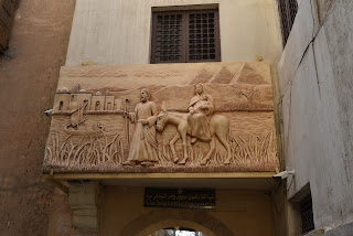 foto da entrada com uma escultura em relevo da fuga para o Egito com Maria em cima do burrico com o Menino e José ao seu lado