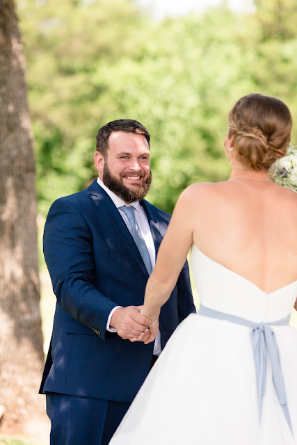 A very special wedding took place on May 19, 2018…besides the one 'across the pond' with Prince Harry and Meghan!  After a five-year engagement, Liz and Chris tied the knot at Stillwater Bible Church, where the couple are regular attendees.      If there is one thing we know about Chris, it is that he is persistent.  Chris said it took him six months to get Liz to start talking to him after first meeting in a sophomore speech class in college.  But from then on, they have become inseparable.  Liz shared that Chris proposed to her at Sandborn Lake as they watched the multi-colored Oklahoma sunset disappear.  It was an "intimate, private moment…special and perfect."  There's no doubt these two were made for each other.        On their wedding day, Liz was stunning in her strapless wedding gown, composed of light and airy tiers of tulle below a perfectly shaped bodice.  Her bridesmaids wore romantic, dusty blue chiffon gowns and carried white hydrangeas, while the bride's bouquet included white roses, baby's breath, snapdragons and hydrangeas with blue accent flowers.  Chris looked dapper in his royal blue suit, dusty blue tie, and two-tone brown, intricately stitched cowboy boots (the bride had cowboy boots on too).      After they exchanged vows, guests were invited to a reception buffet, the cake cutting, and the first dances.  The day was filled with heartfelt moments shared by the people they loved, and before long, the young couple departed amid a throng of well-wishers…headed for a romantic getaway honeymoon to Yellowstone and the Grand Tetons.  Wishing you two a lifetime of love and romantic nights watching the sunset by Sandborn Lake!