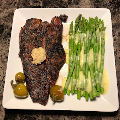 Mid-rare grilled bison chuckeye with steamed asparagus and hollandaise