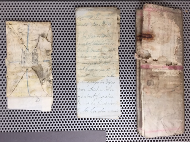 Various documents stained by mould and damp damage.