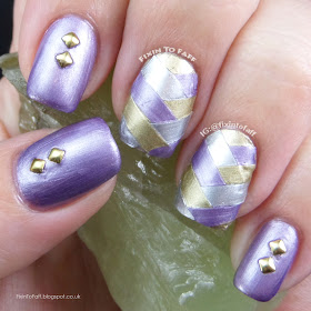 Fishbraid, or fishtail braid nail art using tape and metallic foil finish polishes, accented with studs.