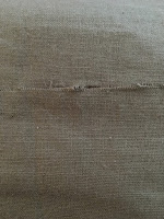 A small, straight horizontal cut in green linen fabric.