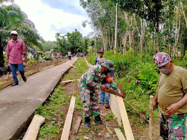 Anggota Satgas TMMD Memotong Papan dan Cerucuk