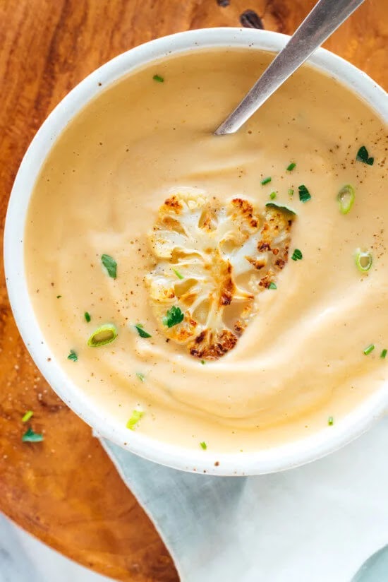 This cauliflower soup recipe is the best! Roasted cauliflower makes it taste amazing, and a little butter (instead of cream) makes it luxuriously creamy. Recipe yields 4 bowls of soup.