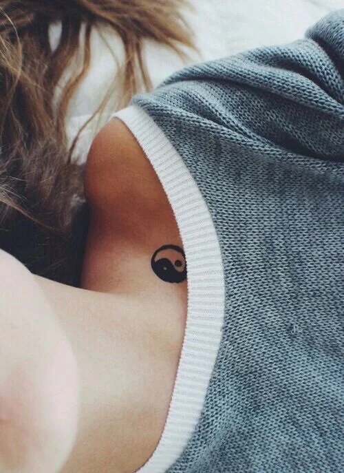 Tatuaje de yin yang en la clavícula