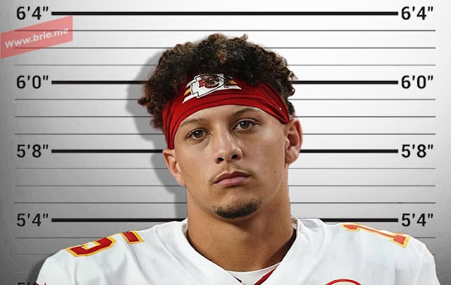 Patrick Mahomes standing in front of a height chart