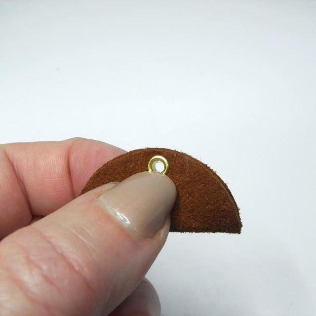 Brown suedehalf circle folded with eyelet set in position
