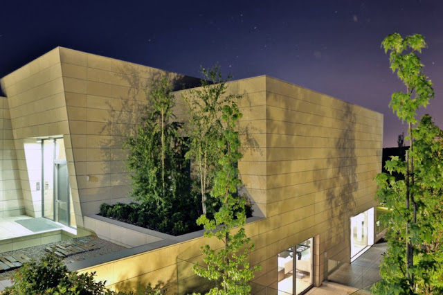 Stone facade of The Memory House by A-Cero Architects at night 