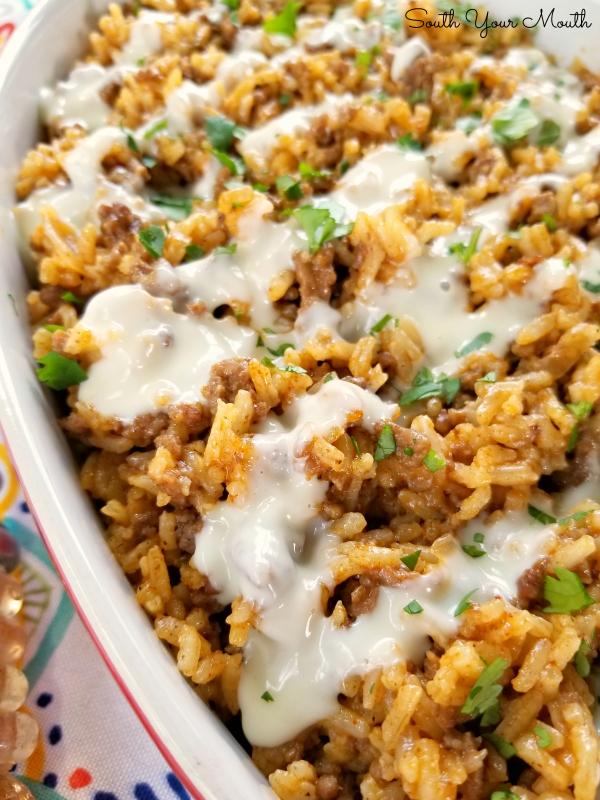 Taco Rice with Queso! An easy one-pan skillet dinner recipe made with ground beef, taco seasoning and Mexican style rice drenched in an easy queso cheese sauce.