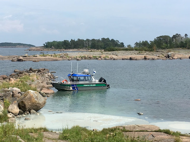 Metsähallituksen vene rannassa. Levälauttaa.