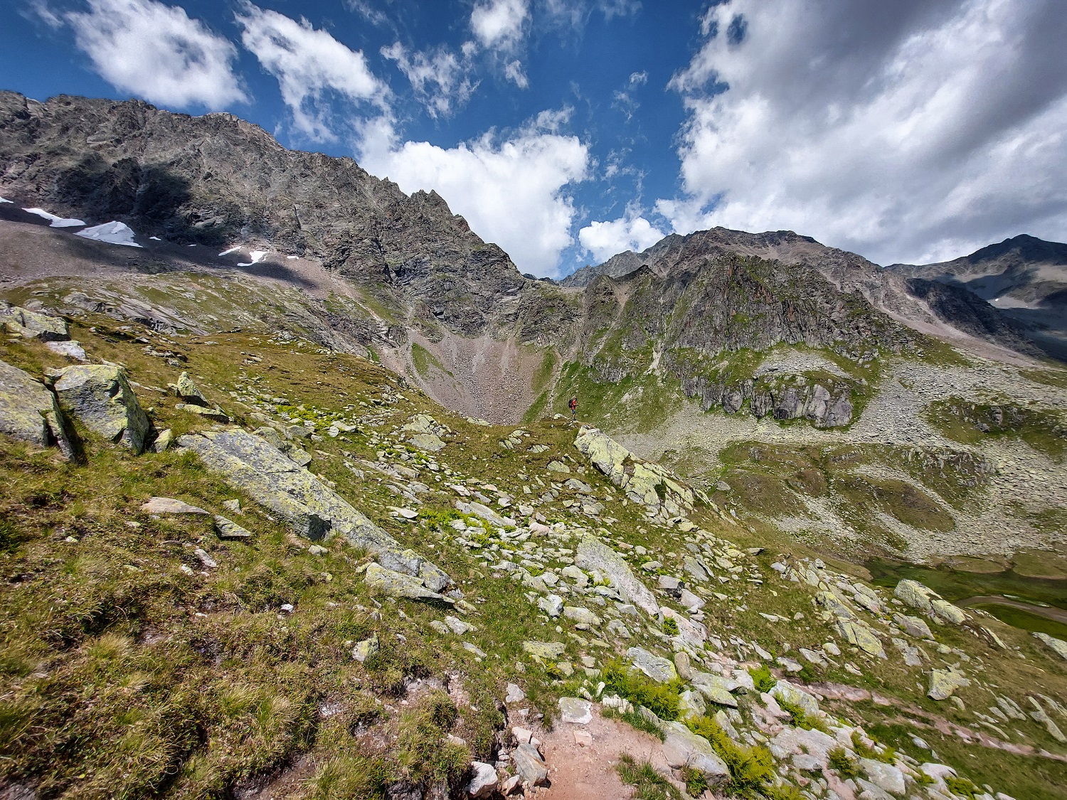 Alpejski widok, łaki, skały, góry, chmury, górski szlak.