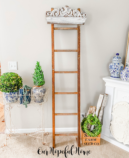 vintage wooden ladder with white pediment hanging from top