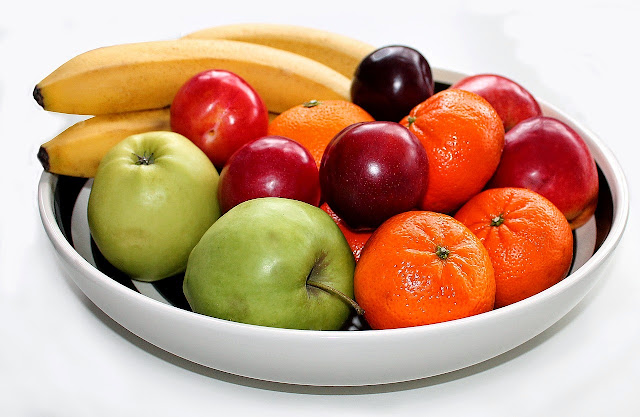 Bowl of fresh fruit: Bananas, tangerines, apples, plums