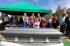 (Photo courtesy Mason Browning) Rachel Jeffs, center, wearing black, stands with her children next to her mother's casket on Aug. 30, 2018, in Centennial Park, Ariz. Her mother, Barbara Jeffs, died of cancer in 2004 at the Fundamentalist Church of Jesus Christ of Latter-Day Saints ranch near Eldorado, Texas. Bodies buried at the ranch have been removed in anticipation of a sale of the property.