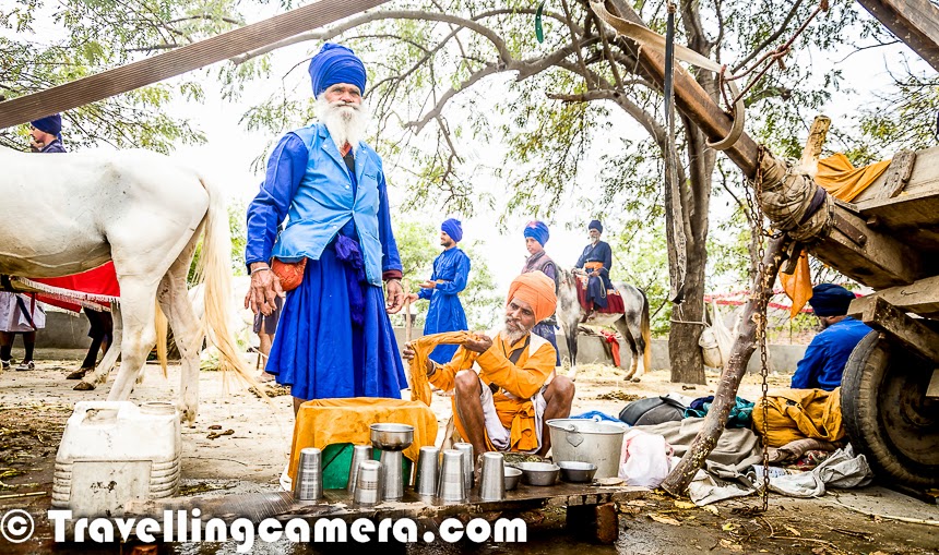 Few weeks back one of my friends pinged me over Facebook to ask if I can join in one of his Photography Trip during Holi. Idea was to join the group of Photographers and help them utilize the basic techniques of Photography. And when it comes to learning and travel, I am always ready. Leading a group of enthusiastic explorers and Photographers is a very good learning experience and, hence, I agreed to join the gang for Hola Mohalla 2014. This Photo Journey shares some moments from the visit to Hola Mohalla, an event that occurs every year at Anandpur Saheb, Punjab (India).We started from Delhi on 16th March at 7am in a Tempo Traveller. Ramit from 'Delhi by Foot' shared some quick facts about Hola Mohalla & its history. It was quite useful to know the background and why this event is called 'Hola Mohalla'. Here is a summary -- Sikh Guru Gobind Singh founded Khalsa at Anandpur Saheb and he asked for 5 volunteers to lead. These 5 leaders are popularly known as 'Panj Pyare'. Hola Mohalla isn't related to Holi at all, and therefore colors are hardly used here. However every year it is celebrated on same day. After a quick introduction to the place by Ramit, most of us chose to take a nap till we arrived at a place to have brunch. After a while, Roli started a conversation about photography basics. We were mainly talking about different shooting modes in DSLRs and what should be used when & associated subjectivity of choice. Apart from Photography we touched upon Softwares & Literature as well :). Jona also heard some of our conversations and planned to join us. By this time, most of the folks were sleeping.After driving for a few hours, we hit Ambala and stopped for a break. We took a 45 minutes break here and enjoyed tandoori paranthas and some pakoras with tea. It was time to refill fuel tank and move ahead towards our destination, Anandpur Saheb. We bypassed Chandigarh and took the shortcut which hits Kharar via Greater Mohali area. Roads near Anandpur town were badly jammed with trucks, karts, buses, cars & bikes. It seemed that whole of Punjab has come to the town for Hola Mohalla Fair. We had to spend approximately an hour in this traffic jam and then we got to know that Punjab chief minister was visiting, which was the main reason for stopping the incoming traffic.We had booked a hotel called 'Simran' with very basic facilities. It seems that Anadpur Saheb had only a handful of hotels because during normal time, one can stay in Gurudwara. Guradwara has sufficient arrangements to accommodate hundreds of folks at any point in time. So there is not much demand for hotels in Anandpur Saheb. The streets were full of people and there were tens and thousands of Sikhs there. After having some rest at the hotel, all of us headed towards to the ground where Nihang Warriors were showcasing their skills to public.We encountered few langars on the way, where Jalebi, Pakoras and food was being served. Before hitting the main ground, we thought of having something at the Langar. We had to put off our shoes before entering into the langar areas and also got to know that everyone of us needed to cover our heads. Everyone had something to cover the head except me and Madhu. There were various shops nearby to buy stuff, Initially it looked quite odd and lot of questions were coming to my mind. I was not able to relate to things which were communicated by leaders on stage and I was wondering about existence of such community in country like India. I was not able to control myself and thought of talking to the Nihang singhs sitting around the corner of main stage. Asked various questions and the way he replied made me feel a bit relieved. Especially when I asked - 'Are you ever tempted to use your weapon wielding skills when you get angry or not in right state of mind', he replied this in detail. It seems that training grounds are there in almost every town where Sikhs are living. They go to these training centers called as Akharas and before the actual training starts, each of them is trained by Jathedar (leader/coach) about ethics of using these weapons and related skills. As a basic principle, no one of them can use these weapons without permission of their guru, except one of the situations. And another thing is that using these weapons for  personal use is restricted. If someone is found using the skills and weapons in undesired way, the community has defined appropriate punishment. More than all these details, I loved the way this guy was explaining all these things to me. Now I was confident that all this is happening for some reasons which this community experiences over time and it;s harmless for overall Eco-system. In fact, I found this a very good way to be united and teach youth about some of the religious values. Whole evening was full of action, music, poets and Khalsa stories. Some parts were boring,  but overall the action filled activities by different groups from various parts of the country were definitely worth experiencing. Some of their leaders and sponsors had come for Hola mohalla from different countries. Apart from demonstrating these skills, few other games are organized during these two days of Hola Mohalla. We had also planned to go for Kabaddi & kho-kho but couldn't find time for that. It seems polo is also played in one of the grounds in Anadpur Saheb during Hola Mohalla. All these events keep happening throughout the night. Some of us moved for dinner at around 9pm and also left at around 10:30pm. Again we preferred to have dinner at Langars only. After dinner, we moved towards Anandpur Saheb market which was full of people moving towards main Gurudwara. We couldn't visit the Gurudwara during these two days because there was significant waiting time involved to reach inside and we were only there for a very short while. We found a sweets shop, had some besan barfi and moved back to our hotel to have some rest and gear up for the most exciting day - Hola Mohalla. While going back towards the hotel, we noticed that most of the folks around these grounds were sleeping in tempos/trucks they had arrived in. Activities were still on at around 11:30pm and many of the folks were sitting on top of buses & trucks to have a clear view. Next day started with delicious breakfast at hotel and then we moved towards Gurudwara campus where various processions go from main Gurudwara to Sheeshganj Gurudwara. While going towards Gurudwara, Ramit took us to a ground full of swings and maut-ka-kuan. All of us watached Maut-ka-Kuan show, which was awesome. Some of us chose to have some snacks and then we moved towards Gurudwara. It was very crowded and at times it was getting difficult to move.Smoking and drinking is strictly prohibited in Anandpur saheb and there is no liquor shop in this town, but bhang was available at every 100 meters in different forms.We kept walking and it was hot outside. There was hardly any action in the market before noon. There were lots of people but hardly anything was happening. Processions were yet to start. Some of us were tired and wanted to get under shade. We chose to have lunch and take some rest.It was quite an experience to walk around these markets in Hola Mohalla fair. While walking around the streets, I observed a very interesting thing. The foreground, where all groups had to gather was occupied by significant numbers of bikes. There were 6-8 policemen who had to ensure that ground gets empty soon to avoid chaotic situation. One of the policemen approached boys and requested them to do some 'seva' by moving these bikes on one side of the road to create a queue. And it was amazing to see a group of 15-20 young boys clearing the space in few minutes. I was super impressed with this act by youth at Hola Mohalla. Then we thought of moving towards the main ground where Hola Mohalla is celebrated in presence of all Nihang singhs and folks from different parts of the country.The above photograph gives a quick glimpse of the main ground where Hola Mohalla is celebrated. This was less than 1% of the crowd around this ground. Folks were settling down and there was not much action when we reached main ground. Still people were coming in and real action was yet to start. Some of the Nihang groups were performing in the middle of this huge ground. I was a bit disappointed by the fact that performances were hardly visible to people sitting on surrounding hills, because many of the folks including media & photographers had surrounded these performers from all the sides. I am sure that folks sitting at a distance would have major difficulties in watching the action happening on ground.Some of the bikers started showing stunts on Hola Mohalla ground znow horses, camels, elephants had started coming in. Final evening on the day of Holi festival is considered as main Hola Mohalla, when real action happens. Horse ride is one of the popular sport of Hola Mohalla. Some of the folks were riding on 4 horses as well. During this race, grass bundles are put in the middle of the ground and these riders have to pick a bundle with a stick when they were racing at a very high speed. It was crazy to see that people had created a narrow lane around the place where these horses run. There is no boundary defined for this race, which means that horses can easily hit folks standing on both sides. Initially I was very uncomfortable going to the front and some photographs and then Ramit encouraged me to go & experience something very special. During this many people step over each other and situation may get chaotic and everything during this time happens instantaneously.This Holi was the most unique one for me. And Hola Mohalla is an event worth experiencing at least once. The warmth and large-heartedness of Sikhs shines through the frenzied activities and unbelievable crowds. A visit to Hola Mohalla can help in getting to know the Sikh culture more closely. Thanks for Ramit, Delhi by Foot & all participants for great company during this exploration !