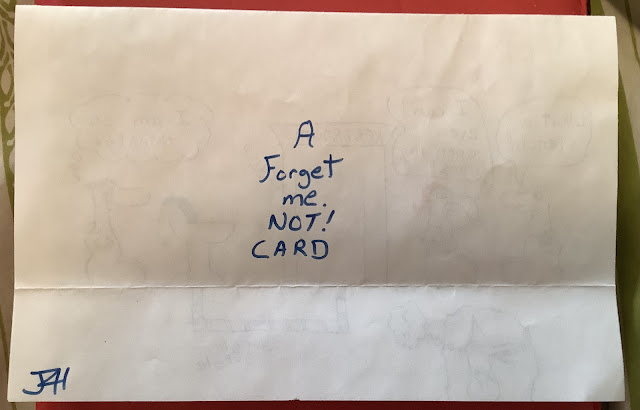 A folded piece of paper with handwritten text that reads, A forget me.  Not!  Card. The initials JLH are in the bottom left corner.
