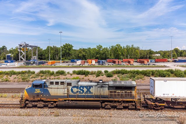 CSXT 100 and I001-16 are westbound, passing the intermodal facility at DeWitt Yard