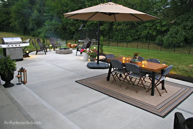 Large patio with outdoor dining and round fire pit