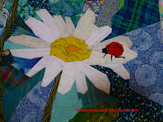 Detail of ladybug on daisy quilt