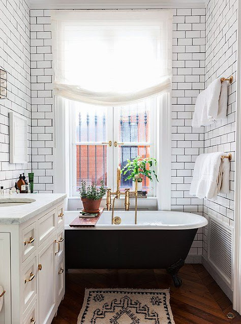 White subway tile with black claw foot tub