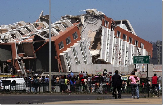 Residents look at a collapsed  building in Concepcion, Chile, Saturday Feb. 27, 2010 after an 8.8-magnitude struck central Chile. The epicenter was 70 miles (115 kilometers) from Concepcion,  Chile's second-largest city.(AP Photo)