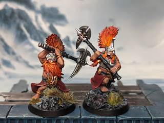Two Vulkyn Flameseeker minis, one male and one female. They are painted with fiery orange hair
