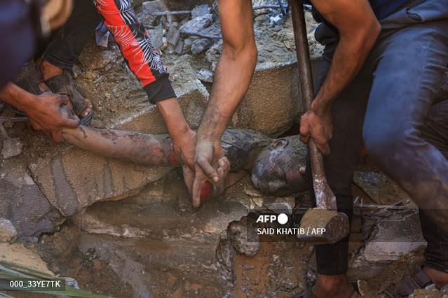 Attempting to get a dead boy of a Palestinian out of the rubble in Gaza  "AFP"