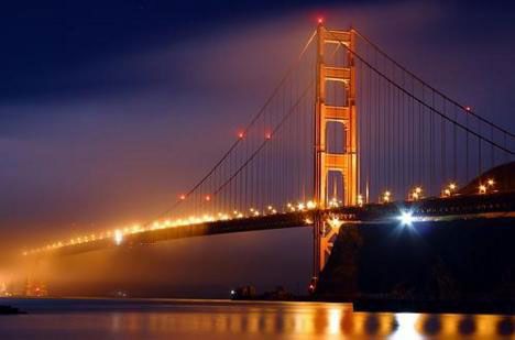 Foto da ponte Golden State, nos Estados Unidos, a noite, com as luzes acessas