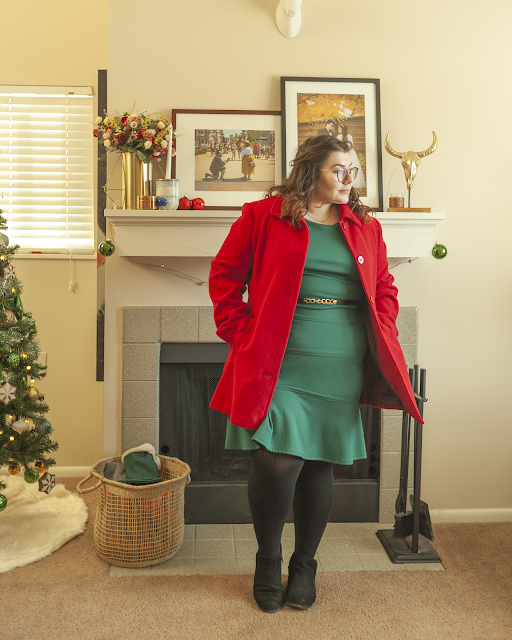 An outfit consisting of a green fluted knee length dress and a red coat.