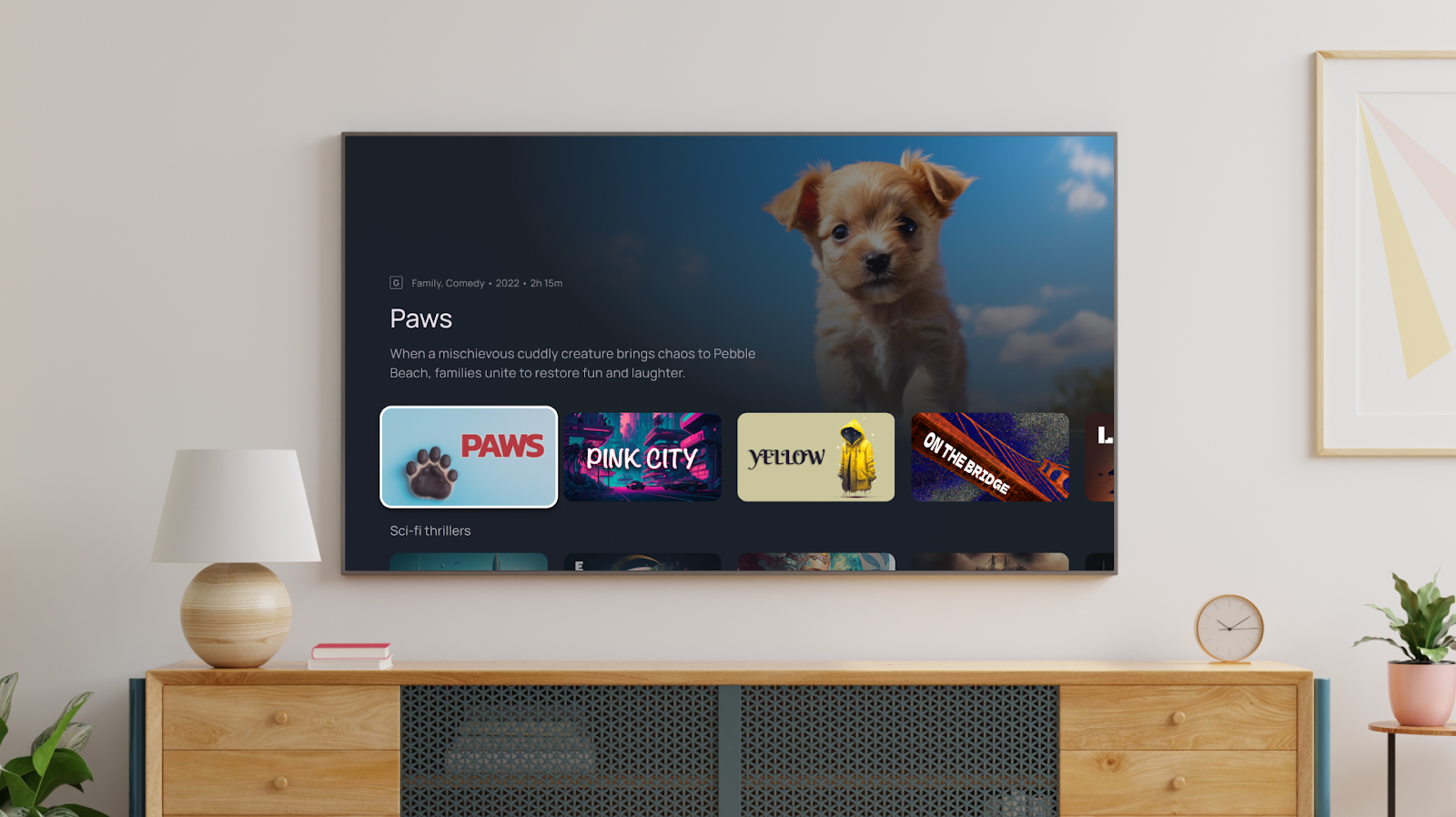 image of a wall mounted, flat screen television in a modern home. The screen is showing the preview for a show titled 'Paws' with an adorable puppy as the show's star, and a Watch Now button