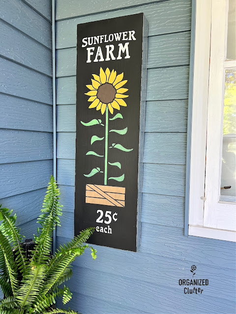 Photo of a galvanized metal sign stenciled with the Sunflower Farm stencil from Old Sign Stencils.