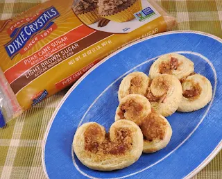 pastries filled with brown sugar and bacon on blue plate with bag of brown sugar