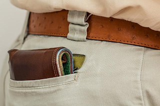 A Man Wearing Brown Leather Belt and Keeping Leather Wallet in Pocket